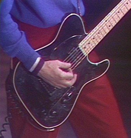 Ca. 1979, with single-bound black Schecter model with Tele-style toggle and black pickguard.